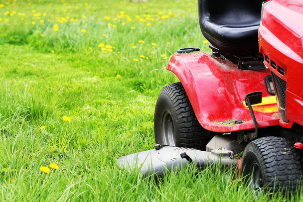 Jardinier conduisant une tondeuse à gazon dans un jardin. Coupe de l'herbe
 . - Photo, image