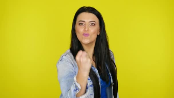 Femme en colère montre un poing à la caméra sur un fond jaune avec de l'espace de copie
 - Séquence, vidéo