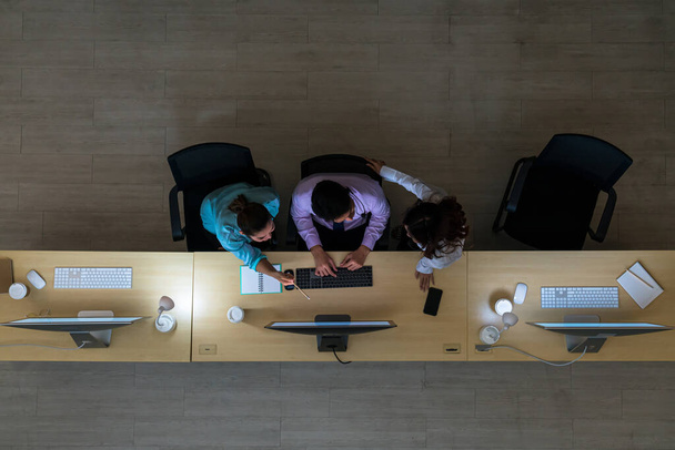 Обзор трех азиатских клиентских служб, которые усердно работают в ночную смену в офисе, отделе колл-центра, работнике и сверхурочной работе, командной работе с коллегами для достижения успеха
 - Фото, изображение