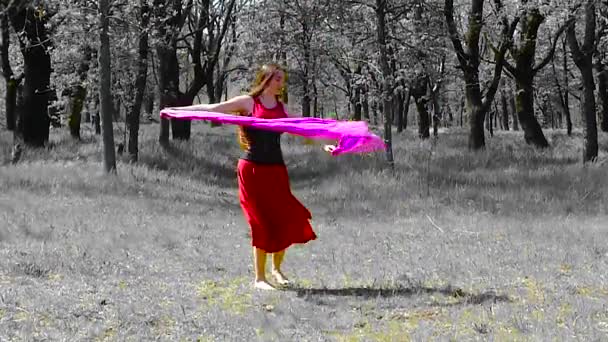 Schöne junge Mädchen mit langen Haaren in einem roten Kleid tanzt im Wald. - Filmmaterial, Video