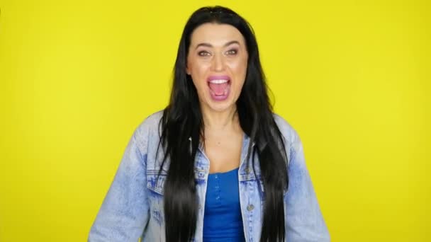 Loca mujer gritando y agitando la cabeza sobre un fondo amarillo con espacio de copia
 - Metraje, vídeo