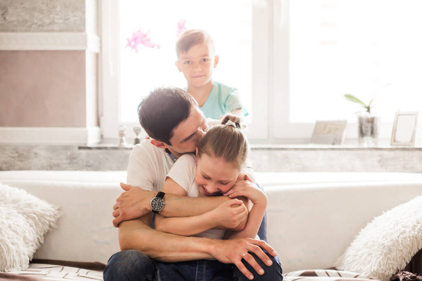Baba ve kızı ve oğlu evde eğleniyor. Eğlenmek, eğlenmek ve çocuklara sarılmak. Yatay fotoğraf - Fotoğraf, Görsel