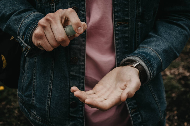 Χέρια ενός άνδρα με αντισηπτικό από τον ιό - Φωτογραφία, εικόνα