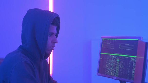 Profilo di hacker africano in felpa con cappuccio che lavora in una stanza piena di schermi
 - Foto, immagini