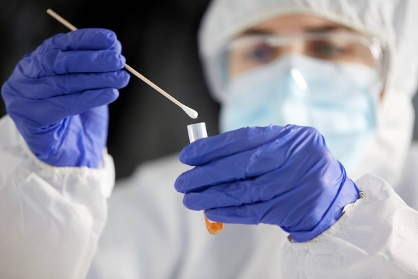 scientist holding beaker with coronavirus test - Foto, Bild