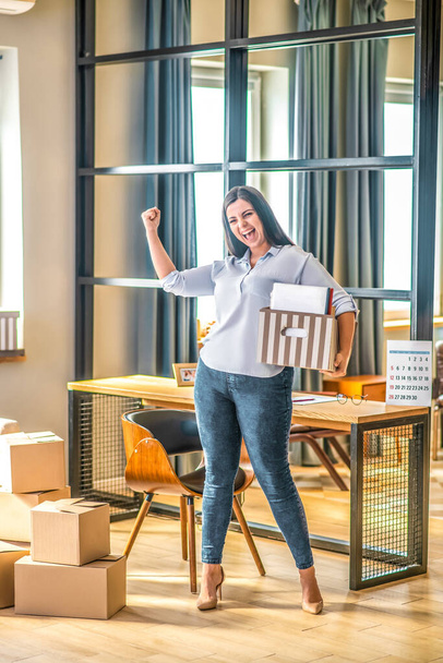 Young woman holding a cardboard and feeling great - Foto, Imagen