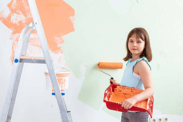Little child painter doing renovation wall. Redecoration, repair and repaint concept. - 写真・画像