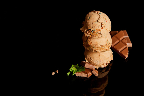 fresh delicious chocolate ice cream with mint leaves isolated on black - 写真・画像