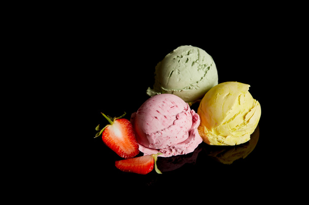 delicious lemon, strawberry and mint ice cream balls isolated on black - Foto, immagini