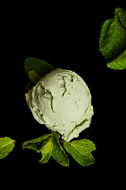 fresh delicious green mint ice cream with leaves isolated on black - Фото, изображение