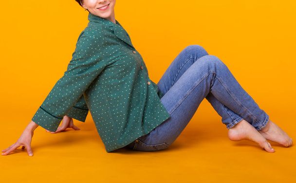 Close up of woman in green home wear. Isolated on yellow background with copy space. - Fotó, kép