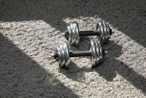 sports at home. Steel dumbbells on a soft Mat . - Photo, Image