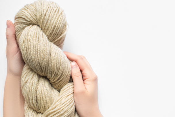cropped view of woman holding beige yarn on white background with copy space - Photo, Image