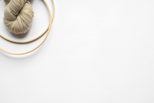 top view of beige yarn and knitting looms on white background with copy space - Fotoğraf, Görsel
