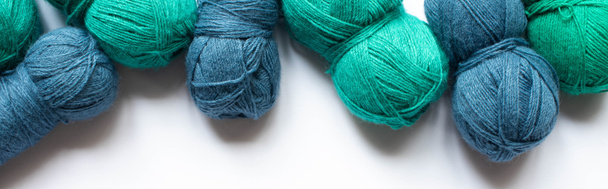 vista dall'alto del filato di lana blu e verde su sfondo bianco, orientamento panoramico
 - Foto, immagini