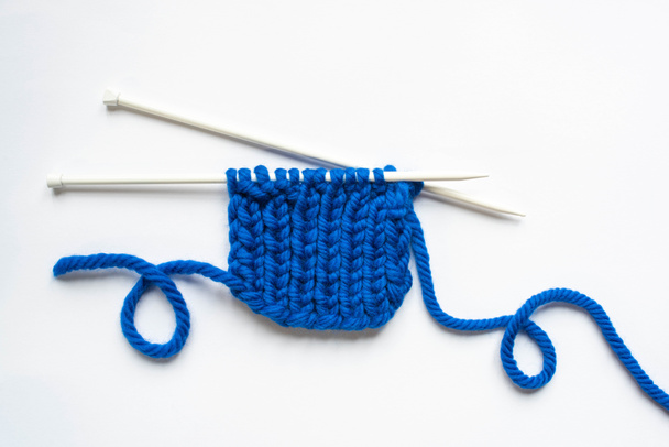 vista superior del hilo de lana azul y agujas de punto sobre fondo blanco
 - Foto, imagen