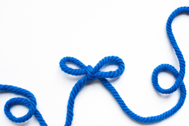 vue de dessus de fil de laine bleue et arc sur fond blanc
 - Photo, image