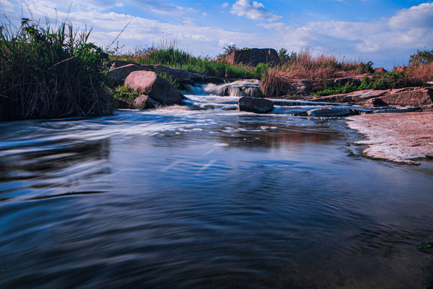 Bir dağ nehrinin fırtınalı su akıntısı. Uzun pozlu çekim - Fotoğraf, Görsel