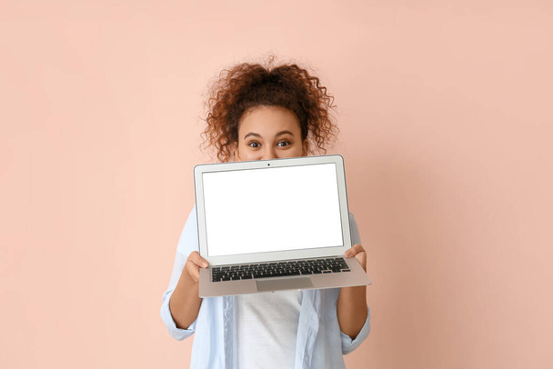 Beautiful young African-American woman with laptop on color background - Φωτογραφία, εικόνα