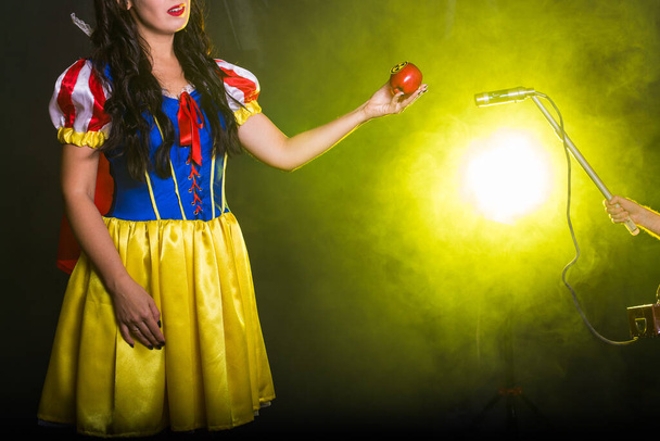 Pomiar zagrożenia, energii jądrowej i promieniowania - dziewczyna trzyma jabłko z symbolem zagrożenia promieniowaniem. - Zdjęcie, obraz