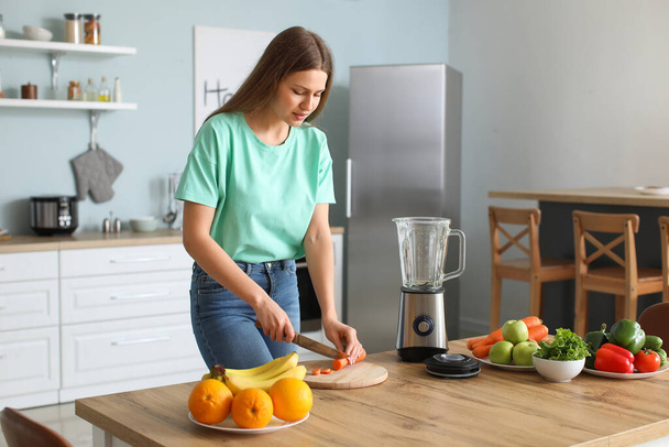 Nuori nainen tekee smoothie keittiössä kotona
 - Valokuva, kuva