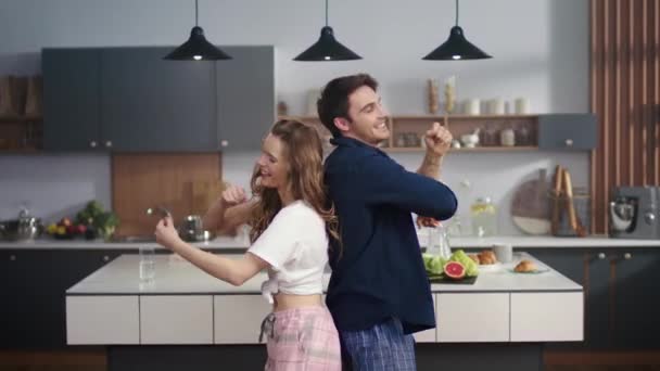 Glückliches Paar tanzt zurück in die heimische Küche. Aufgeregte Freunde, die Spaß haben. - Filmmaterial, Video