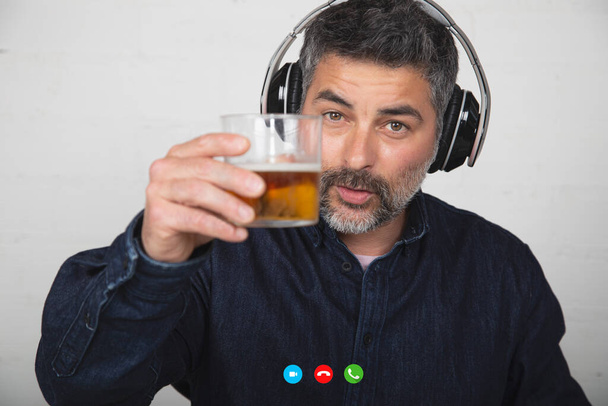 czat na rozmowie wideo: osoba pijąca piwo na platformie technologicznej podczas kwarantanny - Zdjęcie, obraz