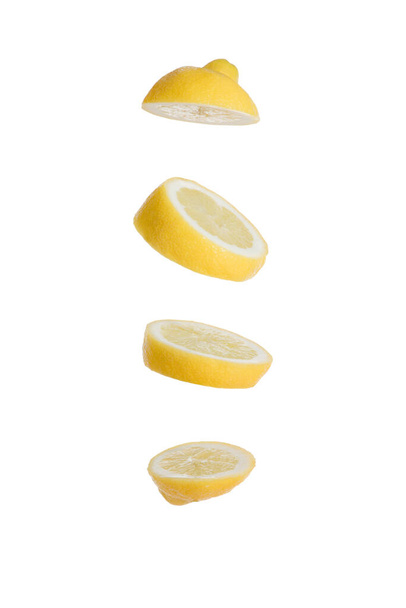 Limón en rodajas aislado sobre fondo blanco flotando en el aire con cuatro grandes rebanadas volando
 - Foto, Imagen