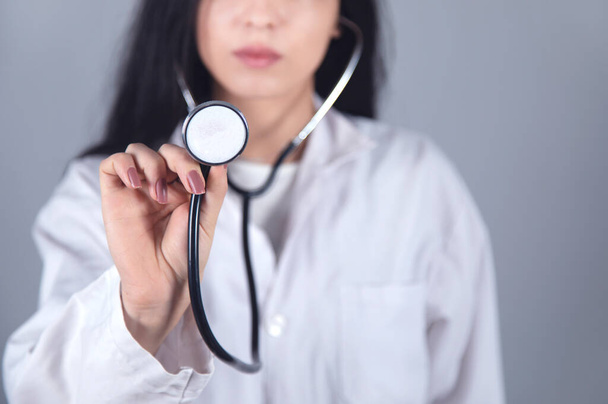 doctor hand stethoscope on grey wall background - Photo, image