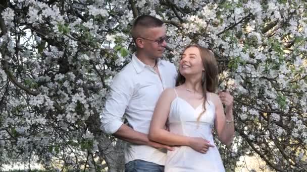 young guy and girl in blooming apple trees in the garden 2020 - Footage, Video