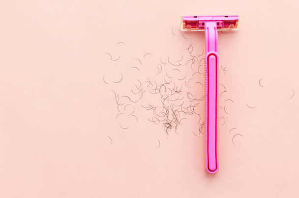 women's shaving machine in pink and hair on a pink background. The concept of women's shaving. - Zdjęcie, obraz