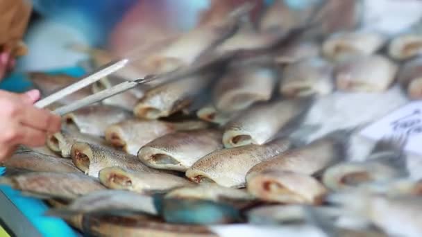 Kurutulmuş balık satan kişi, genellikle dışarıda, sokak satıcılarında, Tayland 'da sokak pazarında. - Video, Çekim