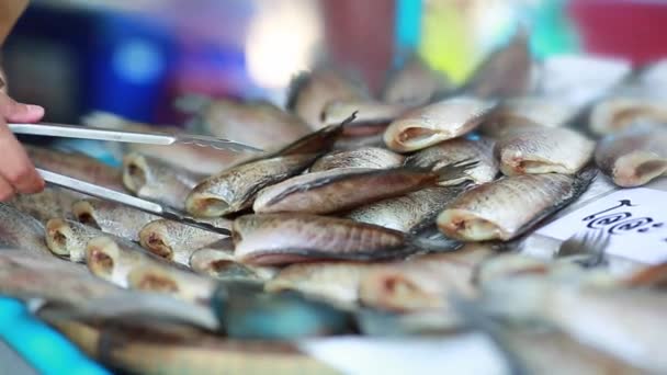 Kurutulmuş balık satan kişi, genellikle dışarıda, sokak satıcılarında, Tayland 'da sokak pazarında. - Video, Çekim