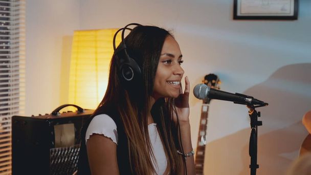 Vocalista femenina negra en auriculares grabando su nueva canción en su estudio en casa
 - Foto, Imagen