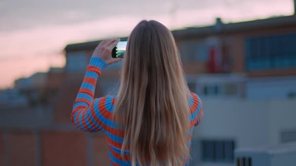 Young millennial woman use smartphone at sunset - Filmati, video