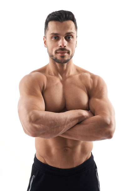 Shirtless bodybuilder posing with crossed arms. - Fotó, kép