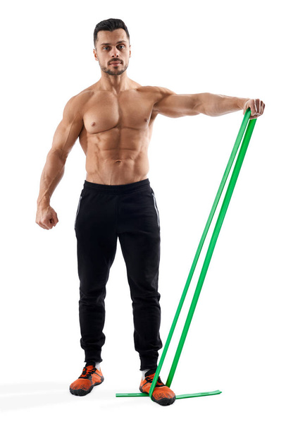 Bodybuilder training arm using resistance band. - Zdjęcie, obraz