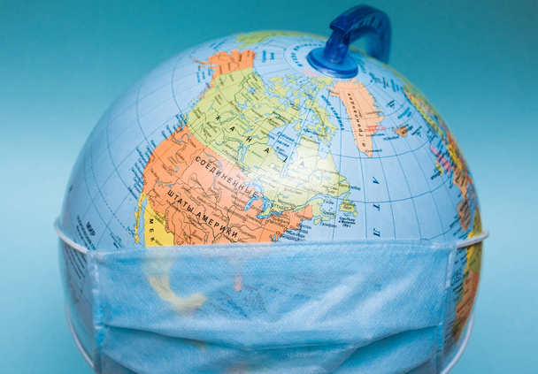 protective medical mask on a globe close-up - Foto, Bild