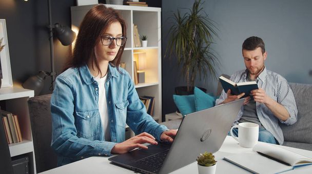 Woman working laptop, husband background - Foto, imagen