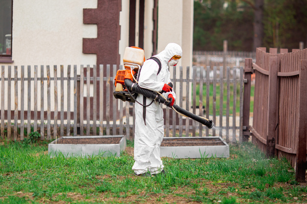 Дезинфекция парков отдыха от коронавируса, работник в защитном костюме с брызгами
 - Фото, изображение