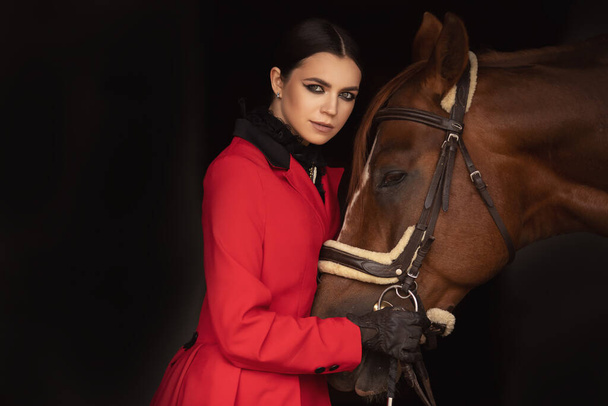 Красивая женщина всадник жокей обнимает свою лошадь - Фото, изображение