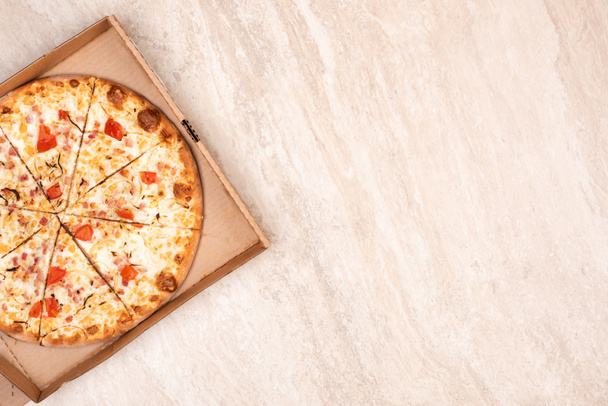 Pizza dans une boîte en carton sur un fond de marbre clair. Copiez l'espace pour votre texte. Vue de dessus, plan plat. Concept d'aliments à emporter
 - Photo, image