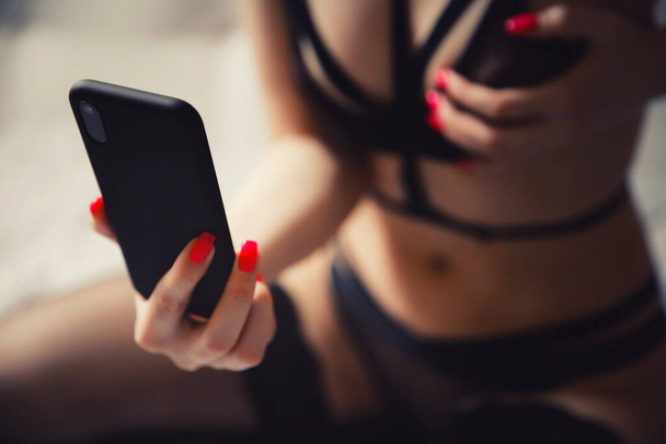 Kaunis nainen kuvaa itseään alusvaatteissa puhelimessa miehelle. Virtuaalinen sukupuoli malli käsite
 - Valokuva, kuva