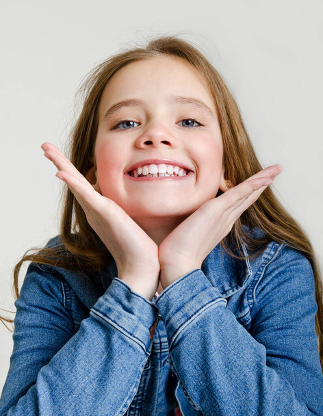 Portrait of adorable smiling little girl child preteen isolated on a white background dental concept - Fotografie, Obrázek