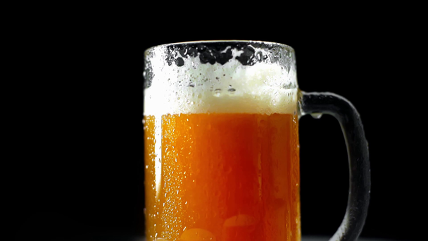 taza de cerveza fresca y fría con espuma aislada en negro
 - Imágenes, Vídeo
