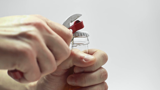 cropped view of man opening beer bottle with can opener isolated on white - Footage, Video