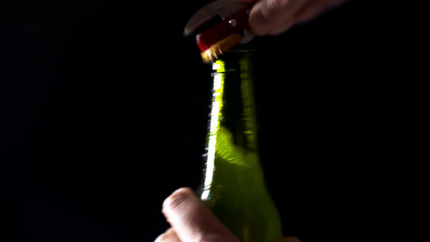 vista recortada de hombre abriendo botella de cerveza ligera aislada en negro
 - Imágenes, Vídeo