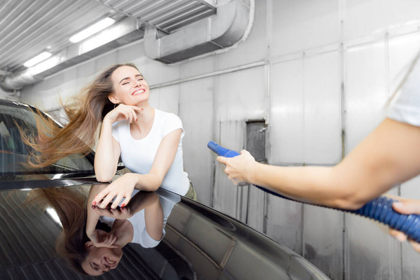 Girl worker uses turbo dryer to remove drops of water. Service car wash express - Photo, Image