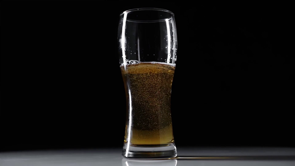 vaso de cerveza ligera fresca aislado en negro
 - Imágenes, Vídeo