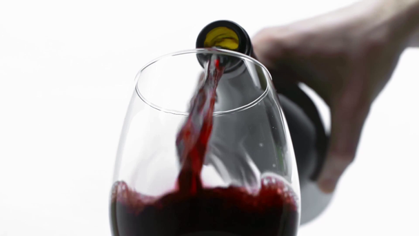 Pomalý pohyb muže nalévání červeného vína ve skle izolované na bílém  - Záběry, video